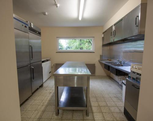 een keuken met roestvrijstalen apparatuur en een raam bij GÎTE LA MARQUISETTE in Houyet