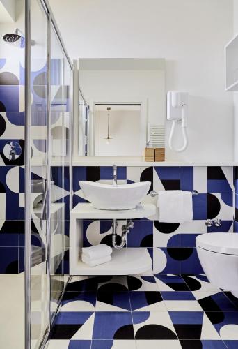 a bathroom with a blue and white checkered floor at Hotel La Fenice in Rimini