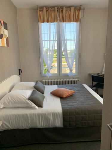 a bedroom with a large bed with a window at L'Escale de la Gare in Saumur