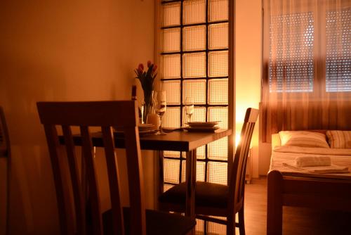 una sala da pranzo con tavolo, sedie e letto di Apartments Take a Break Novi Sad a Novi Sad