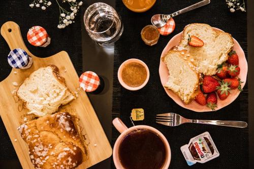 une table surmontée d'une assiette de pain et de fraises dans l'établissement Suite romantique avec Jacuzzi - Hypercentre, Place Jean Jaurès, à Montpellier