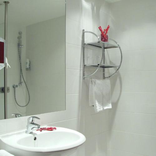 a bathroom with a sink and a shower and a mirror at Hanse Hotel in Soest