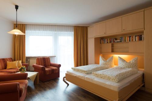 - une chambre avec un lit, un canapé et une chaise dans l'établissement Ferienwohnung Volkmer, à Oberstdorf