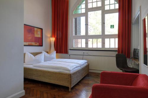 1 dormitorio con cama y ventana grande en Alte Lohnhalle - Industriekulturhotel, en Essen