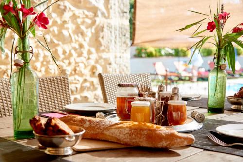 a table with bread and drinks and vases with flowers at Domaine Des Agnelles in Villedaigne