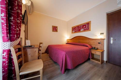 a bedroom with a red bed and a wooden floor at Hotel Elena in Saint Vincent