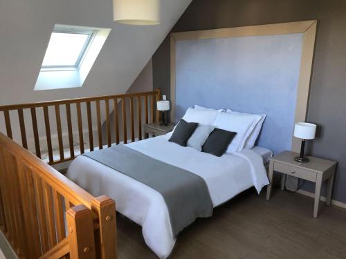 ein Schlafzimmer mit einem großen weißen Bett mit Kissen in der Unterkunft Guilvinec Parc Residence in Le Guilvinec