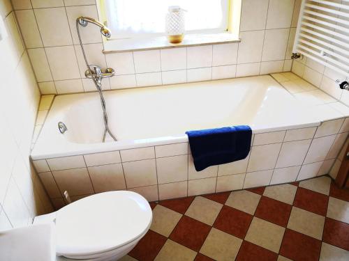 a bathroom with a tub and a toilet and a sink at Havelapartments in Berlin