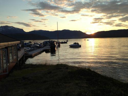 a group of boats docked at a dock on a lake at Garsnes Brygge in Sjøvegan