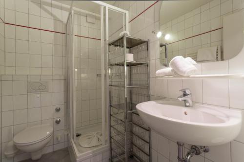 a bathroom with a sink and a toilet and a shower at Ferienwohnung Boland in Oberstdorf