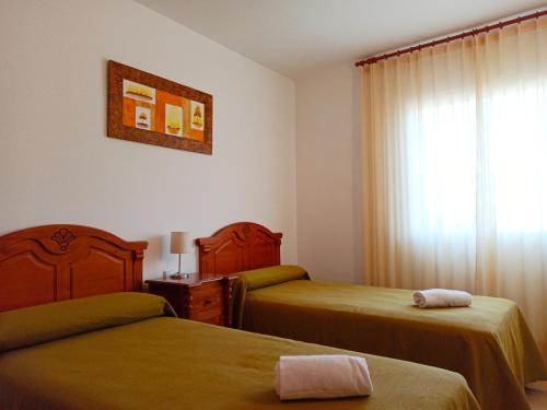 ein Hotelzimmer mit 2 Betten und einem Fenster in der Unterkunft Village Golf Beach in Pals