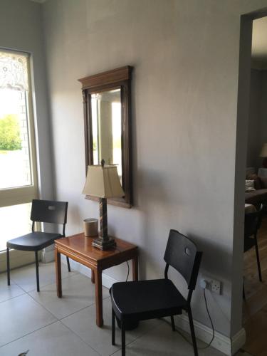 a living room with two chairs and a table with a lamp at The Foxes Covert in Multyfarnham