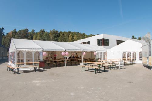 eine Gruppe weißer Zelte mit Tischen und rosa Ballons in der Unterkunft BiG Bed & Breakfast in Grimstad