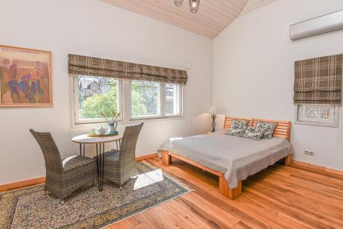 1 dormitorio con 1 cama, mesa y sillas en Geltondvaris, en Palanga