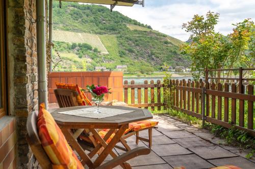 a wooden table and chairs on a patio with a view at Weinhotel Landsknecht in Sankt Goar