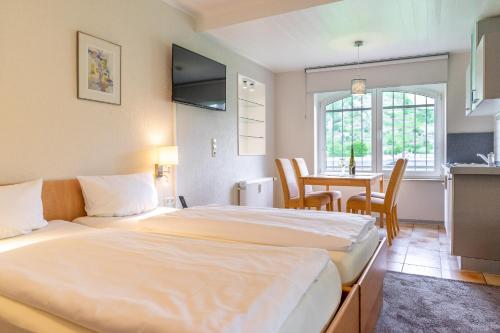 a hotel room with two beds and a table at Weinhotel Landsknecht in Sankt Goar