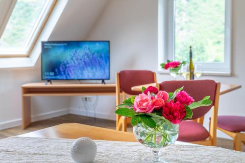 a vase filled with pink flowers sitting on a table at Weinhotel Landsknecht in Sankt Goar