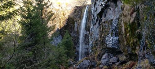 una cascata sul fianco di una montagna alberata di La Villa des Thermes a Le Mont-Dore