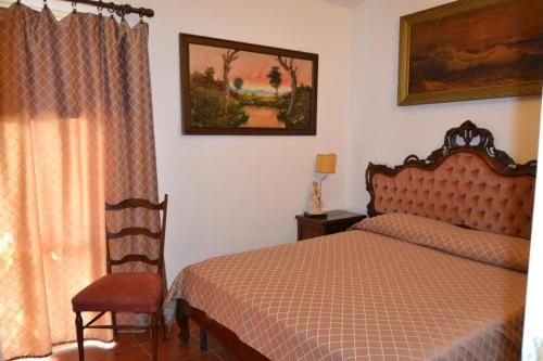 a bedroom with a bed and a chair and a window at da lina in Porto Santo Stefano
