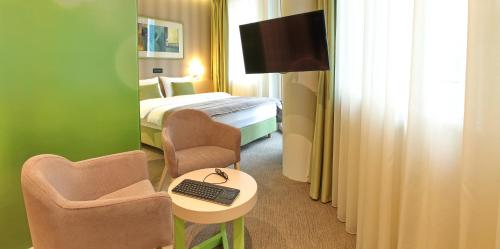 a hotel room with a bed and a desk with a keyboard at Hotel Argo in Belgrade