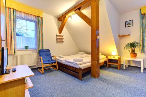 ein Schlafzimmer mit einem Bett und einem Stuhl in einem Zimmer in der Unterkunft Pension Seidl in Špindlerův Mlýn