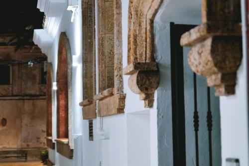 un couloir d'un bâtiment avec des murs et des fenêtres blancs dans l'établissement Hotel Avenida Playa, à Zahara de los Atunes