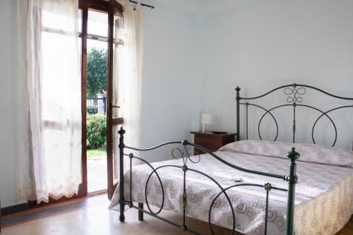 um quarto com uma cama, uma janela e uma porta em Villa Nicol affittacamere em Marina di Ragusa