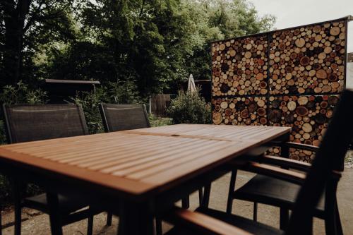 a wooden table with chairs and a fence with logs at Ferienwohnung Alte Wäscherei in Kitzingen