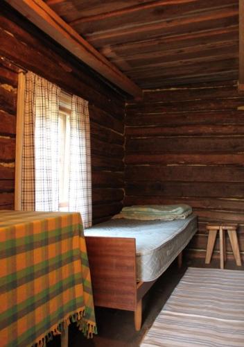 a small room with a bed and a window at Löydön Kartano Camping in Mikkeli