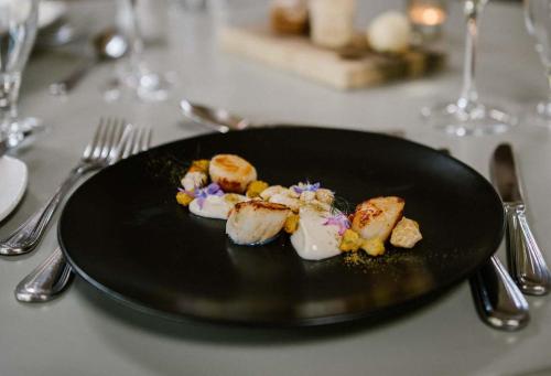a black plate with food on a table at Tankardstown House in Slane
