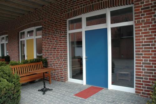 a building with a blue door and a bench at Göcke's Haus und Garten - Remise in Wettringen