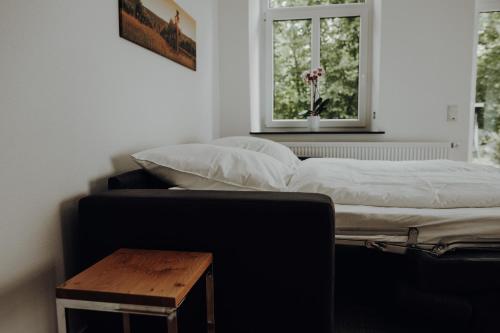 a bed and a table in a room with a window at Ferienwohnung Alte Wäscherei in Kitzingen