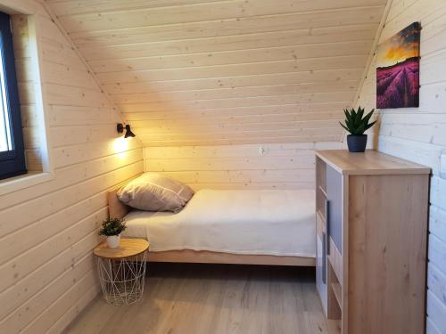 レバルにあるDomki Na Kasztanowejの小さなベッドルーム(ベッド1台付)が備わる木造キャビンです。
