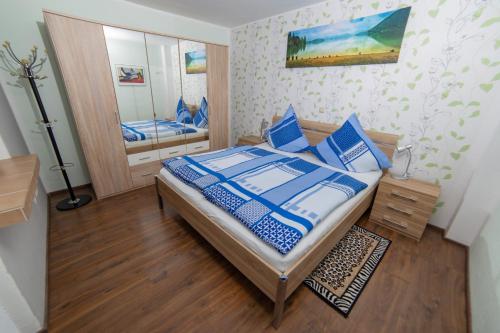 a bedroom with a bed with blue pillows and a mirror at Ferienwohnungen Schorn in Burg (an der Mosel)