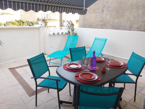 - une table et des chaises sur la terrasse dans l'établissement Bandol Appartement Terrasse, à Bandol