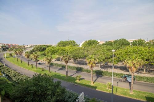 a street with palm trees on the side of a road at Appartement les Falaises in Cap d'Agde