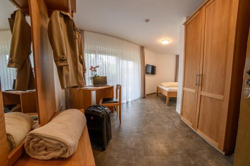a room with a hallway with two beds and a table at Hotel- Restaurant Zum Schwan in Waldfischbach-Burgalben