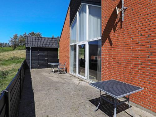 una mesa de picnic sentada fuera de un edificio de ladrillo en 8 person holiday home in Hanstholm, en Vigsø