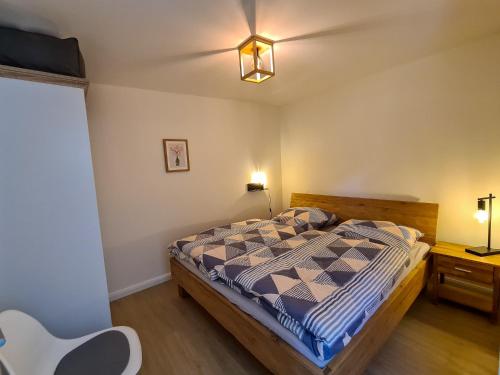 een slaapkamer met een bed, een tafel en verlichting bij Apartments Gezeitenfluss in Tönning