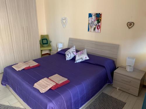 a bedroom with a purple bed with towels on it at L'Agrifoglio Dell'Etna in Trecastagni