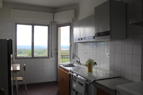 a kitchen with a sink, stove and a window at Albergue Turístico Silleda in Silleda