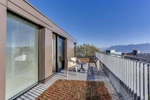 a balcony with a table and chairs on a building at Hôtel des Patients in Lausanne