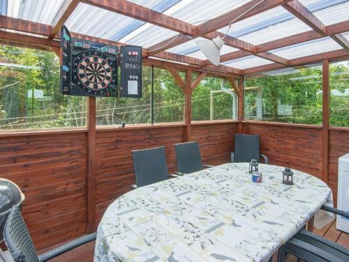 a dining room with a table and a dart board at 4 person holiday home in Juelsminde in Snaptun