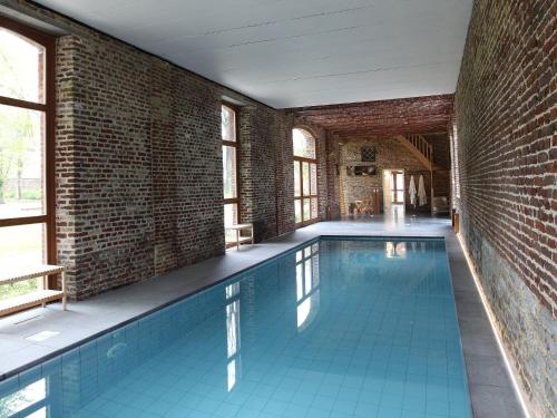 una piscina cubierta con una pared de ladrillo en Cosy holiday home in Wanze with sauna, en Wanze