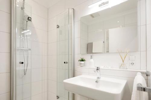 uma casa de banho branca com um lavatório e um chuveiro em WeinQuartier Minges em Kirrweiler
