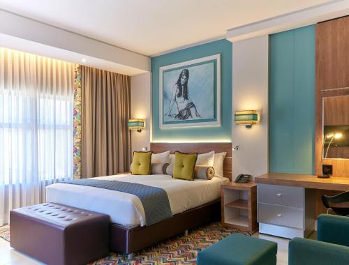 a hotel room with a bed and a desk at Metcourt at Emperors Palace in Kempton Park