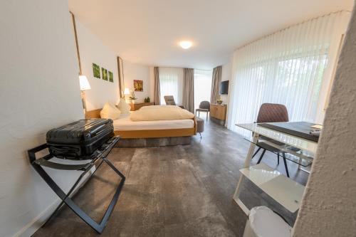 Habitación de hotel con cama, mesa y escritorio. en Hotel- Restaurant Zum Schwan en Waldfischbach-Burgalben