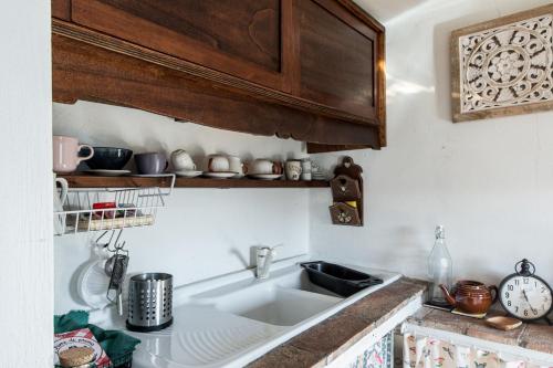 kuchnia ze zlewem i drewnianymi szafkami w obiekcie Casa Marghera House Winery Bikes w mieście Pitigliano