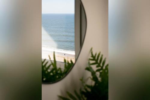 a mirror on a wall with a view of the ocean at NOUVELLE VAGUE Modern Ocean View STUDIO w balcony - Swimming Pool in Biarritz