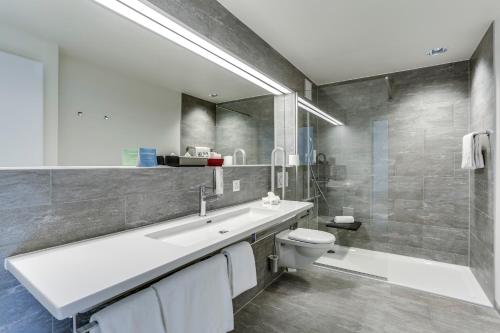 a bathroom with a sink and a toilet and a shower at Hôtel des Patients in Lausanne